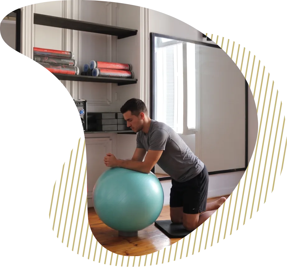 A member kneeling into a stability-ball stretch in the Canopus studio